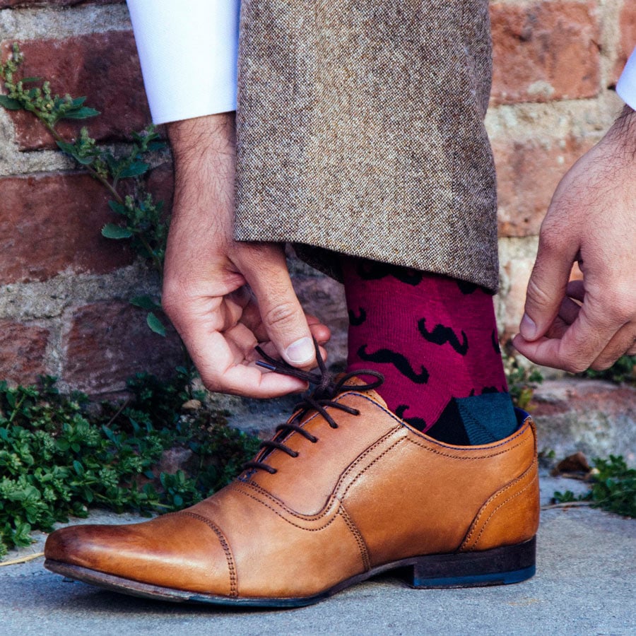 Brown shoe with maroon mustache pattern sock