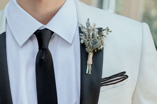 White suit with black lapel and black necktie