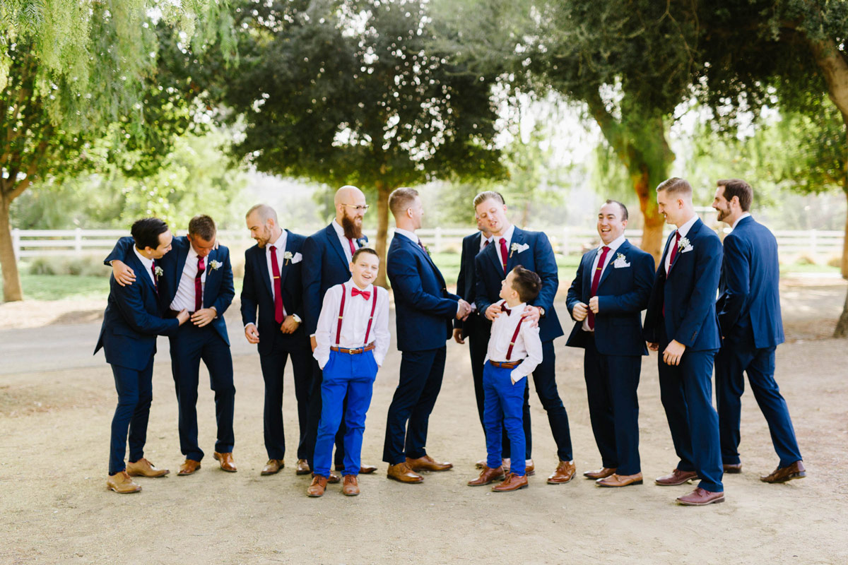 Groomsmen wearing dark navy suits with red ties.com neckties