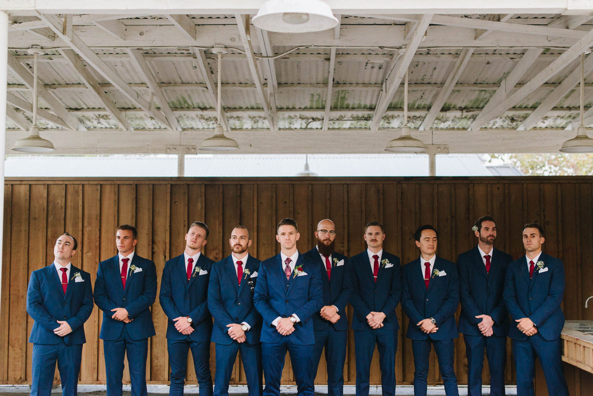 Groomsmen posed with Ben wearing blue suits and red Ties.com neckties
