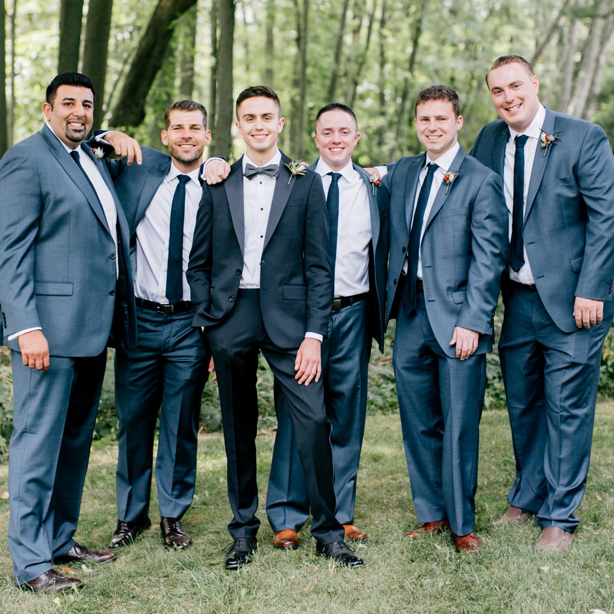 Groomsman wearing blue-gray suits standing with Tom