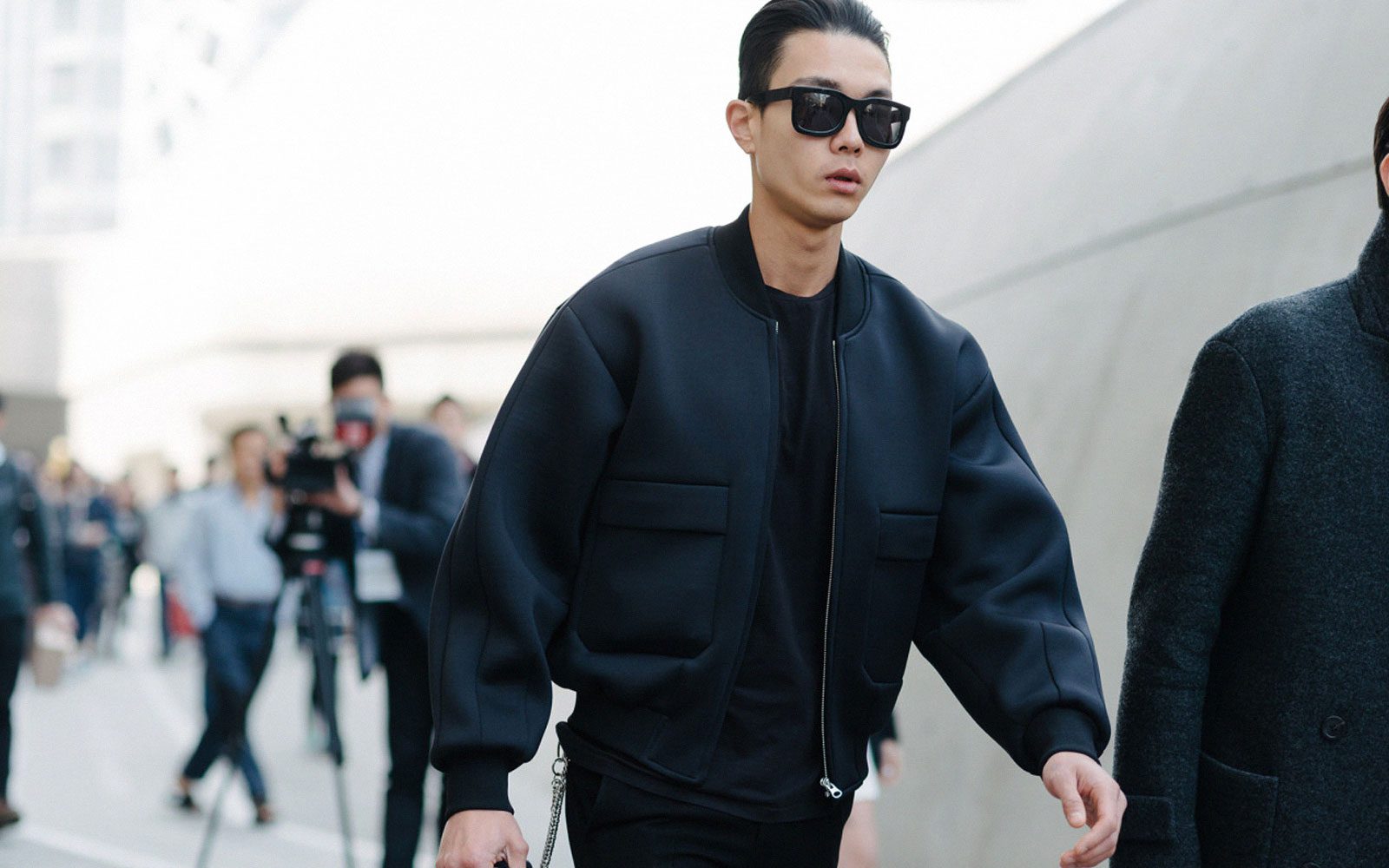 Man wearing all black with black bomber jacket and black sunglasses