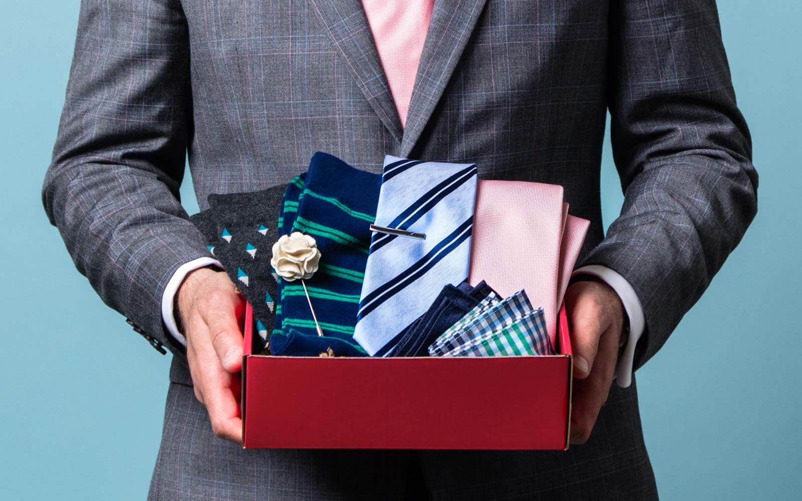 Man holding Ties.com gift box with various items