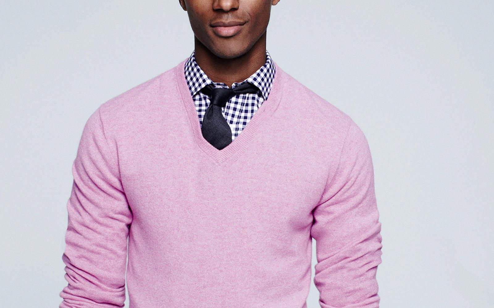 man wearing pink v-neck sweater over a shirt and tie