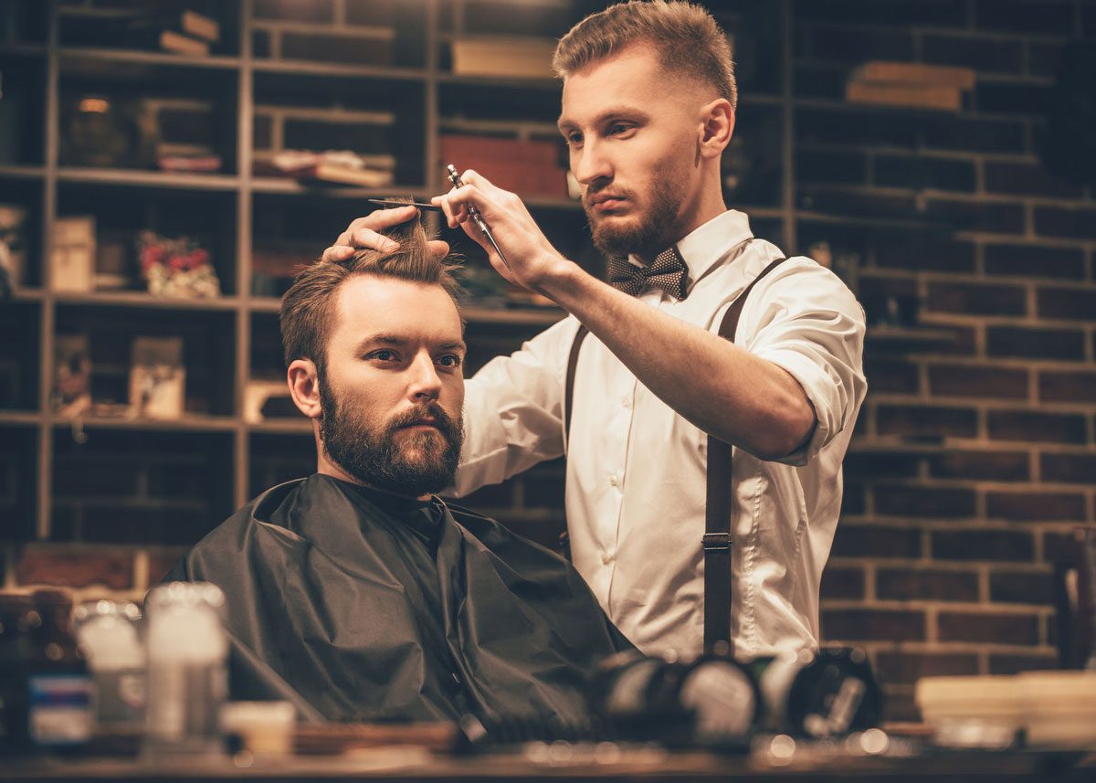 Hairstylist cutting a man's bangs