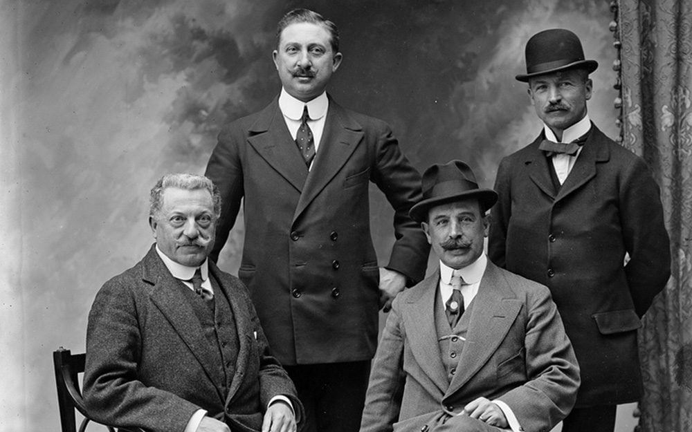 Men in 1910s wearing simpler suits