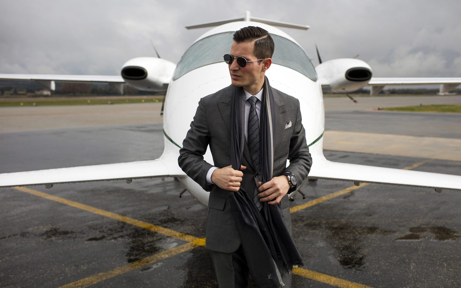 Man wearing suit standing in front of private plane