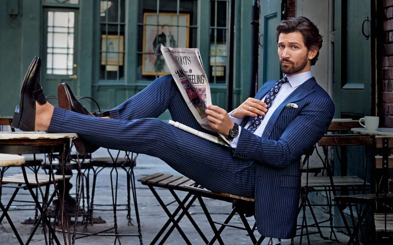 Man reading the newspaper wearing a blue suit