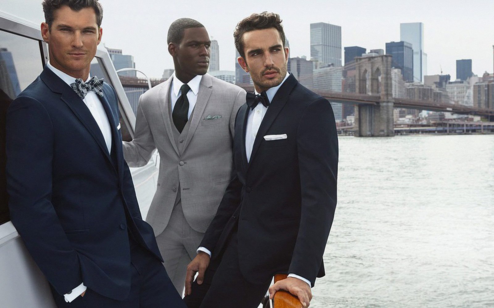 Three men in suits standing by Hudson river