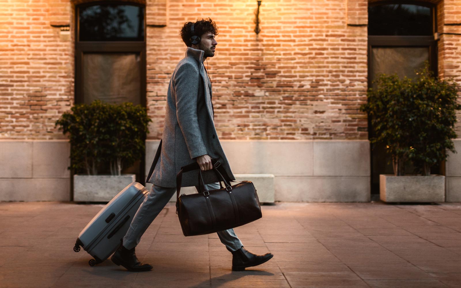 man walking with briefcase and suitcase