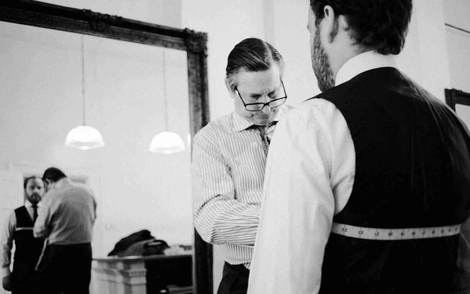 man getting chest measured at a tailor