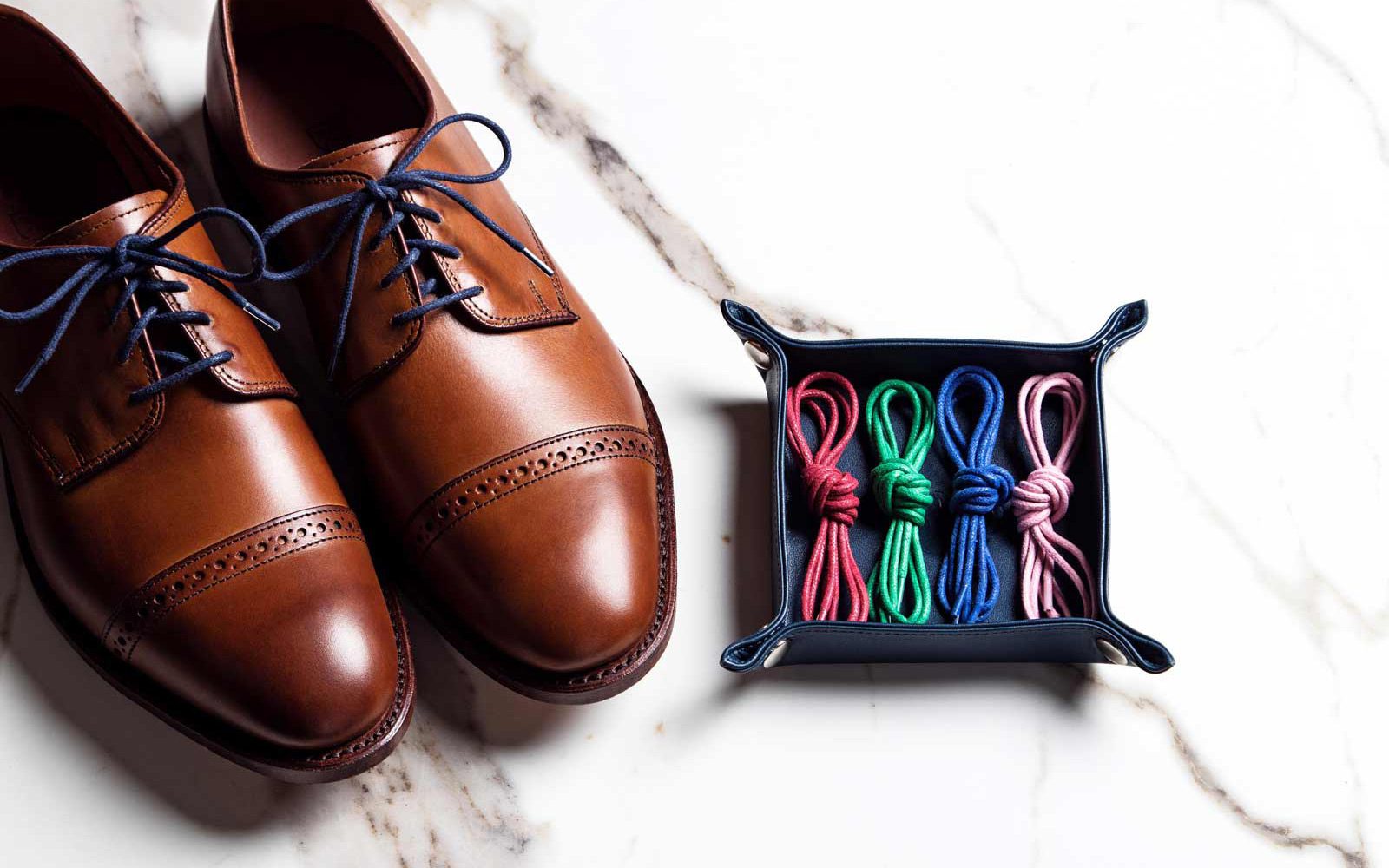 Dress shoes next to colorful laces
