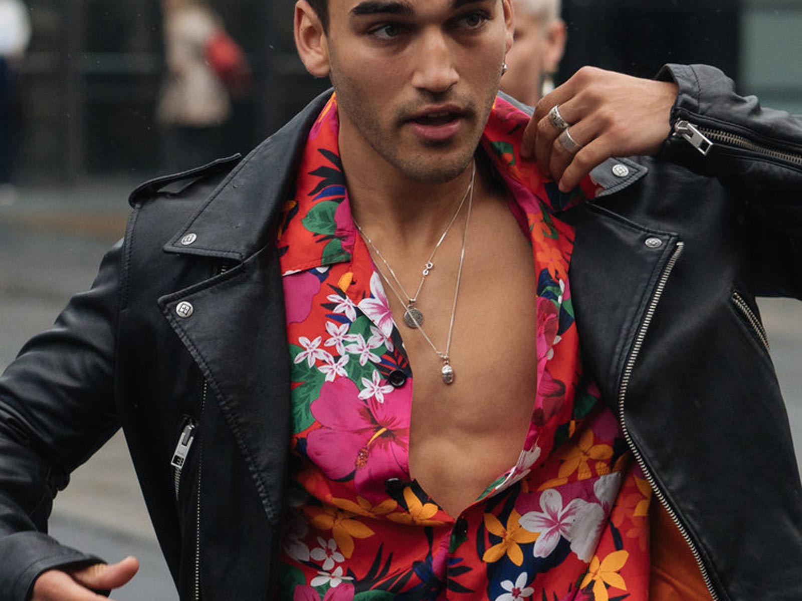 Man wearing bright floral shirt and leather jacket